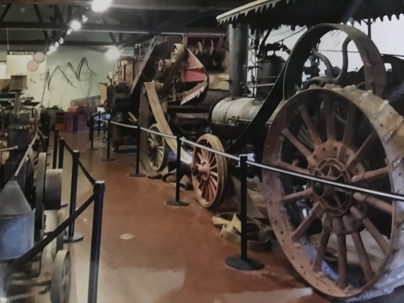 Interior view of the museum, that shows old tractors and farming equipment being displayed. 