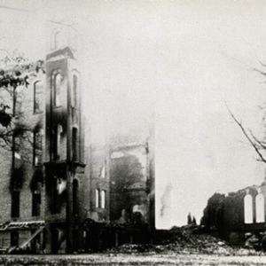 The ruins of Old Main after the fire, where most of the tower is gone and there is a large pile of rubble. 