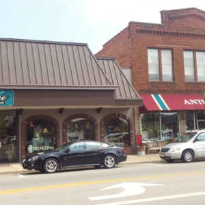 A side view of West Liberty street, including an antique store and some parked cars. 