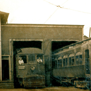 Two trains partially in the doors of a station. 