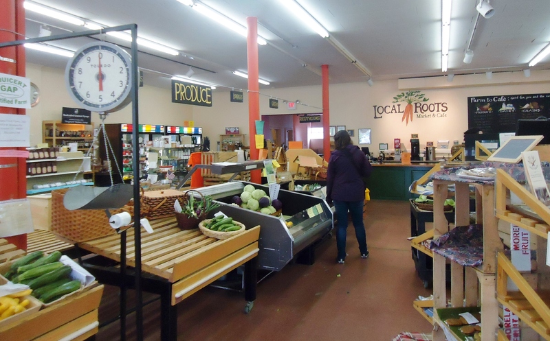 The inside of Local Roots, which consists of shelves for produce and other specialty food products, and a counter for the Cafe in the back. 