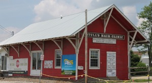 The modern train station, with a sign on it that says "Stull's Hair Clinic" 