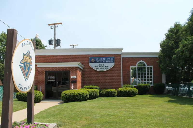 The front of a one story brick building with a sign in front of it that says "knights of columbus" 