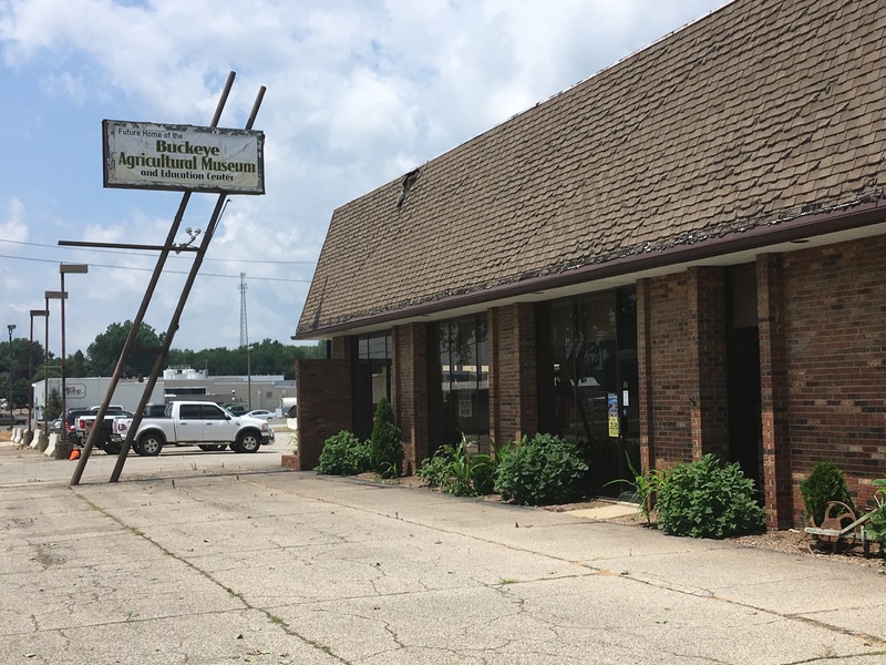 View of the building, which is a one-story brick building with a low roof. 