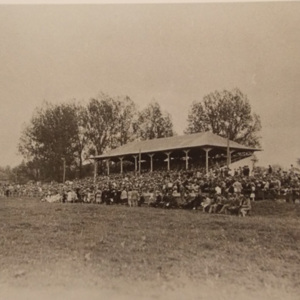 A crowd sitting in and around a pavilion to watch the goings-on of the fair 