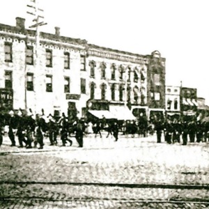 Groups of men marching down the street 