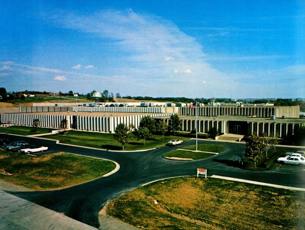 An aerial photo of the Rubbermaid headquarters, which is an extremely large cement block building with a parking lot in the front. 