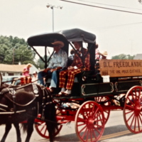 A horse-drawn wagon with red wheels. 