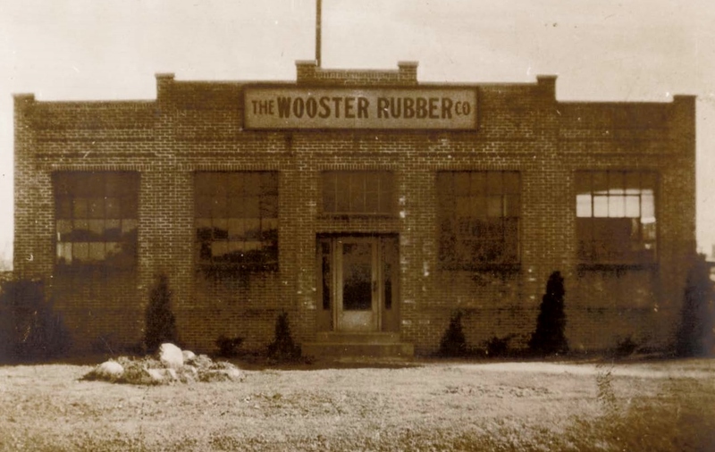 A brick building with a sign that says "The Wooster Rubber Co"