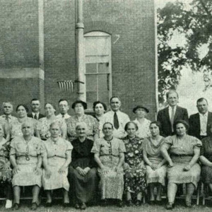 A group photograph with 11 people standing in the back and 8 people sitting in the front, circa 1939. 