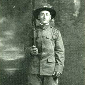 Portrait of Venanzo Tomassetti, dressed in a military uniform and holding a rifle in WWI. 
