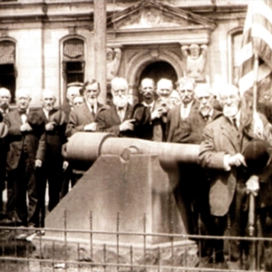 A crowd gathers in front of the courthouse around a canon. 