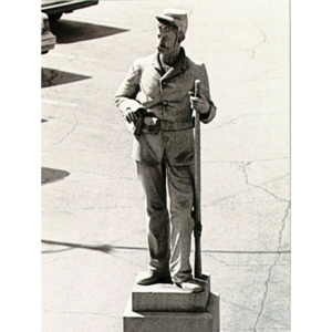 Statue of a man in a military uniform, holding a rifle. 